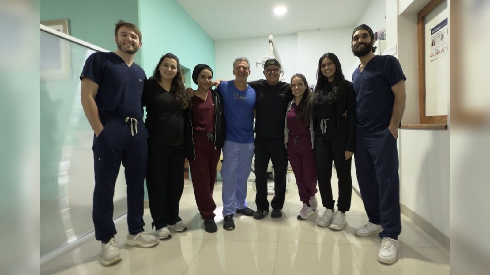 Eight 3rdSET course participants together in scrubs in the clinic hallway